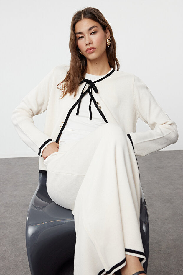 On-model seated view of ecru cardigan and long skirt set